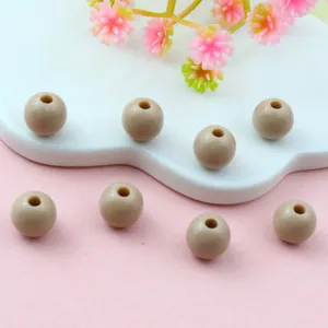 Close-up detail of smooth light brown acrylic round loose beads for DIY jewelry making.