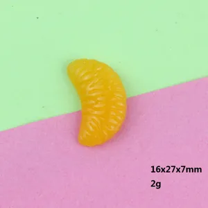 Dettaglio ciondolo fetta d'arancia in resina, mini cabochon di frutta per gioielli fai da te.
