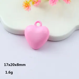 Close-up view of pink acrylic heart pendant, smooth glossy finish with a practical hanging hole.