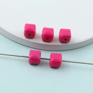 Detailed view of bright pink faceted acrylic cube beads, perfect for DIY jewelry making.