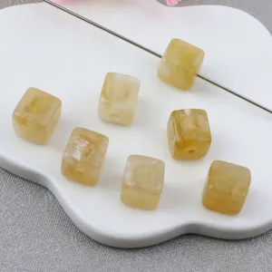 Detailopname van lichtgeel gemarmerde vierkante acryl kralen voor sieraden maken.