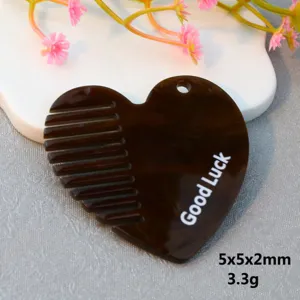 Detailed close-up view of a heart-shaped brown acrylic comb accessory with Good Luck print.