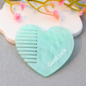 Acrylic heart-shaped comb detail view, mint green pattern with Good Luck letter print.