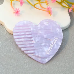 Heart shaped acrylic hair comb accessory with cute Good Luck print, purple hair tool detail.