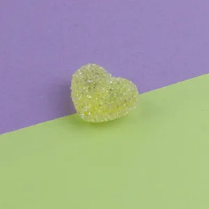 Close-up of yellow green glitter heart acrylic sugar bead, detail view for DIY jewelry.
