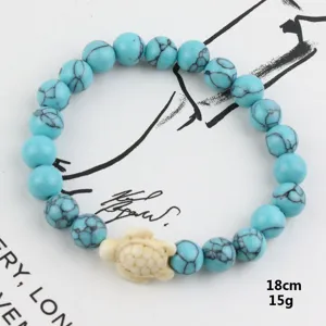 Close-up of blue turquoise beaded bracelet with cute turtle charm, detailed texture view.