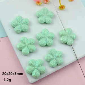 Close-up of glitter mint green flower beads, hole design for jewelry DIY making details.