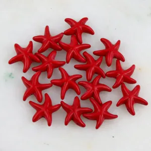 Detalle cuenta estrella de mar roja primer plano, superficie lisa con agujero para joyas.