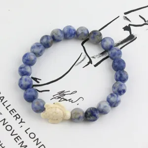 Blue stone beaded bracelet with white turtle charm, elastic design for women daily wear.