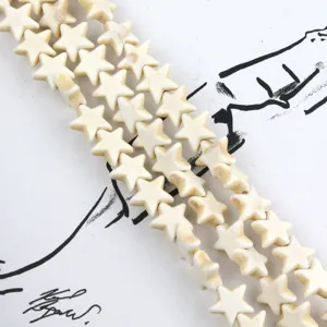 Close up view of creamy white star shaped beads, perfect for DIY jewelry making and crafts details.