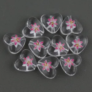 Detail view of 15mm clear acrylic heart beads with pink flower print for DIY craft accessories.
