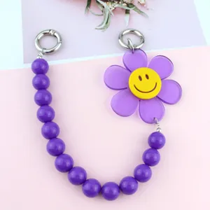 Closeup of the purple acrylic bead chain featuring a cute smiling sun flower pendant for phone cases and bags.