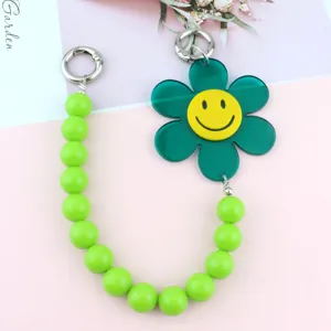 Green acrylic bead phone charm with cute smiley flower pendant for phone cases and bags.