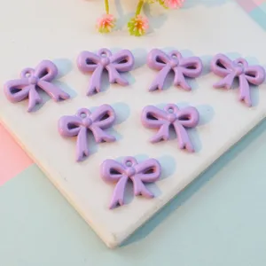 Purple acrylic bow pendants with hanging holes for DIY jewelry making and accessories.