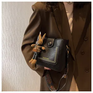 Elegante borsa a secchiello nera da donna con tracolla larga e simpatico ciondolo coniglio.