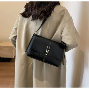 Close-up detail view of the elegant black leather shoulder bag featuring a stylish gold metal clasp.