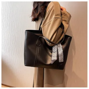Detail shot of the elegant black leather tote bag with stylish scarf for daily commuting.