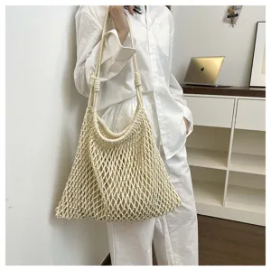 Detailed view of beige woven hollow shoulder tote bag, casual summer beach vacation style.
