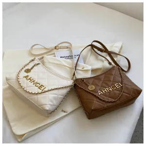 Quilted shoulder bag detail featuring metal chain strap and elegant embossed logo styling.