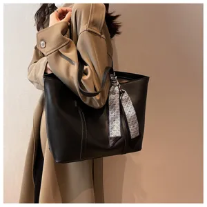 Classic black leather tote bag for women, stylish commuter shoulder bag with patterned ribbon.