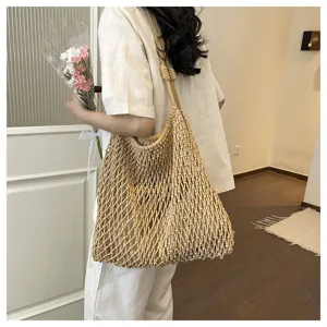 Detailed view of casual beige woven hollow shoulder tote bag with spacious design for summer.