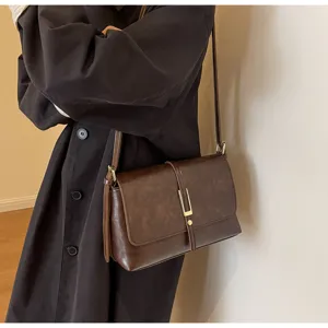 Detail shot of the dark brown vintage shoulder bag, featuring a metallic closure buckle.