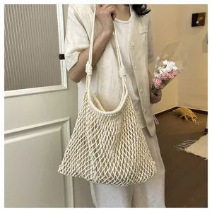 Detailed view of beige woven hollow net tote bag, casual summer beach shoulder bag for women.