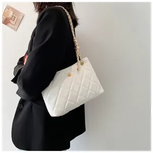 Detailed view of the stylish white quilted shoulder bag with gold chain and chic camellia accent.