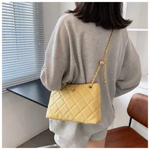 Yellow quilted underarm shoulder bag with chic chain strap, spring fashion trend accessory.
