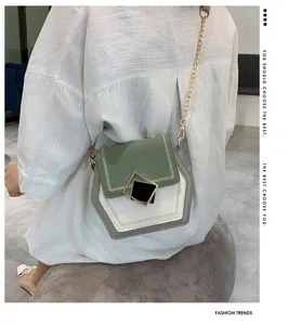 Detail shot of a chic green and white colorblock crossbody bag with gold chain and clasp.