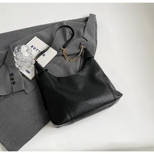 Black litchi pattern leather shoulder bag, retro commuter tote with metal chain strap.