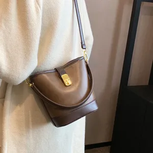 Retro brown leather bucket bag for women, stylish crossbody and shoulder bag with metal lock.