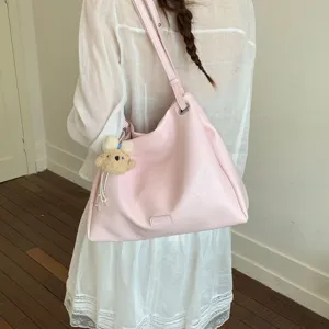 Stylish pink shoulder tote bag for women, large capacity casual commuting handbag with charm.