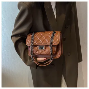 Brown quilted chain shoulder bag detail shot showing classic diamond stitching and metal lock.