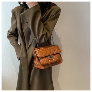 Close-up view of the brown quilted shoulder bag with metal chain and twist lock detail.