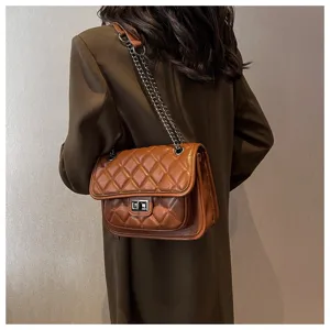 Detailed view of women's brown quilted chain shoulder bag, elegant crossbody square design.