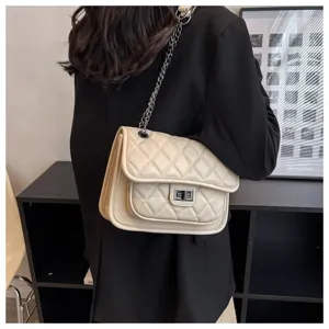 Detail view of quilted chain shoulder bag in beige with elegant metallic lock clasp.