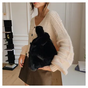 Close-up detail of the stylish black faux fur knot handbag showing soft plush texture.