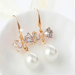 Elegant rose gold drop earrings featuring sparkling triangle cubic zirconia and dangling pearls.