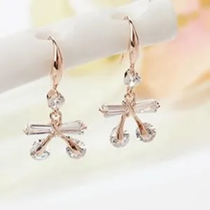 Close-up detail shot of elegant rose gold crystal drop earrings hanging on display stand.
