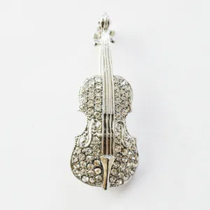 Close-up of silver violin rhinestone brooch, sparkling crystal musical instrument pin.