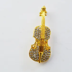 Close-up detail of a gold-plated violin brooch inlaid with sparkling clear rhinestones.