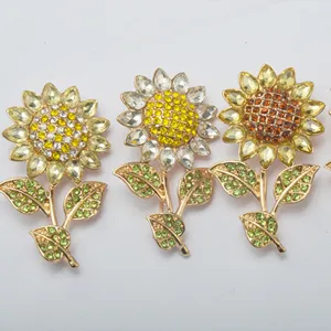 Exquisite rhinestone sunflower brooch pin with sparkling crystal petals and green leaf accents for women.