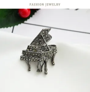 Close-up detail of a delicate rhinestone grand piano brooch made of durable alloy material.