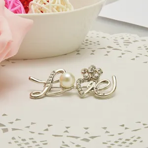 Silver LOVE letter brooch with sparkling rhinestones and imitation pearl. Perfect clothing accessory.