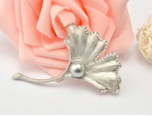 Detailed view of an elegant silver ginkgo leaf brooch featuring sparkling rhinestones.