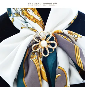 Detail view of rhinestone flower scarf ring buckle with faux pearl and chain scarf.