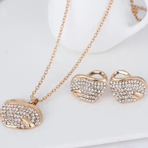 Ensemble de bijoux collier et boucles d'oreilles cœur strass doré, détail élégant.