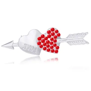 Detailed shot of a silver double heart and arrow brooch featuring sparkling red rhinestones.