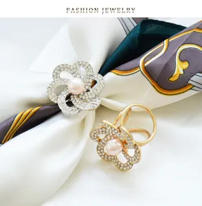 Detailed close-up of rhinestone and pearl flower scarf ring buckle, elegant design.